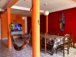 a dining room with a table and two hammocks at Pousada Kawaii in Arraial d'Ajuda