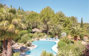 - une vue sur la piscine bordée de palmiers dans l'établissement Amazing Home In Roujan With Kitchen, à Roujan