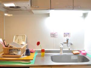 a kitchen counter with a sink and a sink at Guest House Fukutomi - Female Only in Naha +58 photos