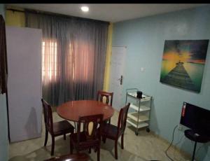 a dining room with a wooden table and chairs at XrisBun Apt 1BR - Laderin GRA in Abeokuta