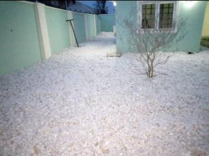 un cortile coperto da neve con un edificio e un albero di XrisBun Apt 1BR - Laderin GRA ad Abeokuta