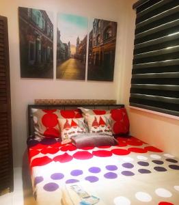 Bett mit einer roten und weißen Bettdecke in einem Zimmer in der Unterkunft Cozy Boo Bed and Breakfast near Enchanted Kingdom by Dynel in Santa Rosa
