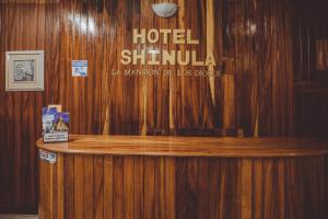 un cartel de shibuya de hotel en una pared de madera en Hotel Shinula, en Huehuetenango