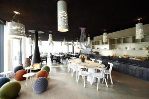 un restaurante con mesas y sillas blancas y una cocina en Hotel mein inselglück en Reichenau