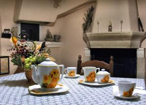 a table with tea cups and a vase with flowers on it at Il Centro Storico in Posta Fibreno