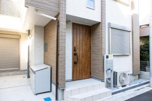 東京にあるY's HOTEL KAMEARIの木製のドアと冷蔵庫が備わる家