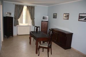 ein Esszimmer mit einem Schreibtisch, einem Tisch und Stühlen in der Unterkunft Bed and Breakfast Casale Nardone in Atina