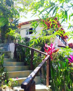 eine Treppe, die zu einem Haus mit einer rosa Blume führt in der Unterkunft Vista Verde in Morro de São Paulo