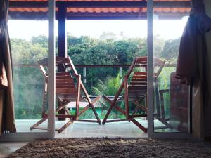 un par de sillas sentadas en un porche cubierto en Vista Verde en Morro de São Paulo