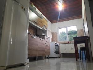 uma cozinha com um frigorífico e uma mesa em Vista Verde em Morro de São Paulo