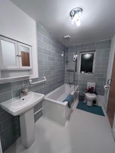 a bathroom with a sink and a tub and a toilet at River Bay in Cardiff