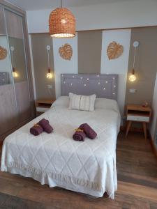 Un dormitorio con una cama con almohadas moradas. en DESCANSO IDEAL IV "el placer de los detalles" en Mar del Plata