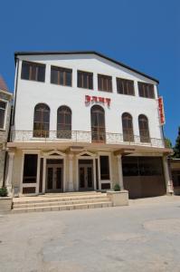 a large white building with a sign on it at Elit Hotel in Derbent