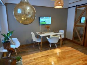 uma sala de jantar com uma mesa e cadeiras brancas em DESCANSO IDEAL IV "el placer de los detalles" em Mar del Plata
