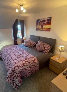 ein Schlafzimmer mit einem großen Bett mit Kissen darauf in der Unterkunft Luxury Portrush Holiday Homes - The Green, Portrush Sleeps 12 - 5 bedrooms in Portrush