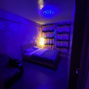 a purple room with a bed and a lamp at Аэропорт in Irkutsk