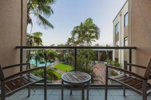 a balcony with two chairs and a table at Mermaid Waters Hotel by Nightcap Plus in Gold Coast