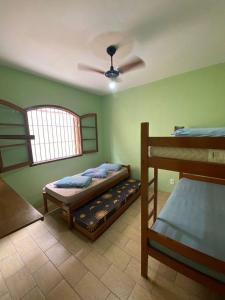 a bedroom with two bunk beds and a ceiling fan at Chalés Beto Amá in Ubatuba