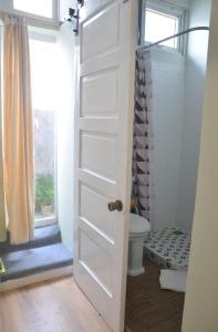 a bathroom with a door leading to a toilet at Evangeline House in Da Lat