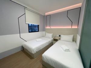 a small room with two beds and a window at GG Hotel Bandar Sunway in Petaling Jaya