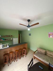 a living room with a bar and some stools at Chalés Beto Amá in Ubatuba