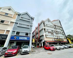 um parque de estacionamento com carros estacionados em frente aos edifícios em GG Hotel Bandar Sunway em Petaling Jaya
