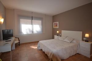 a bedroom with a bed and a flat screen tv at Hotel Rural Seixalvo in Sanxenxo