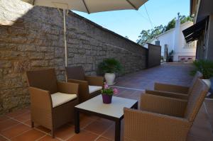 a patio with chairs and a table and an umbrella at Hotel Rural Seixalvo in Sanxenxo
