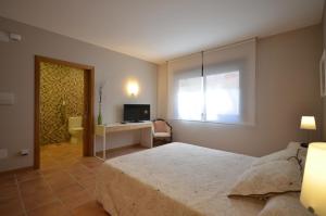 a bedroom with a bed and a desk and a television at Hotel Rural Seixalvo in Sanxenxo