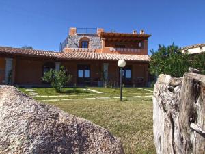 a house with a large rock in front of it at I Mandorli in Lotzorai +34 photos