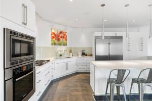 a kitchen with white cabinets and a counter with stools at Modern Gated 8 Bedroom Mansion Built on 5 Acres in Grainger