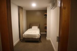 a small bedroom with a bed in a room at Empire Apartments SU 2 Marthastraat in Paramaribo
