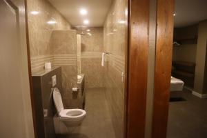 a bathroom with a toilet and a glass shower at Empire Apartments SU 2 Marthastraat in Paramaribo