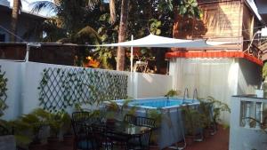 a patio with a hot tub and a table and chairs at Villa Baywalk Goa - 200 meters from Morjim Beach in Morjim