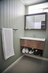 a bathroom with a sink and a mirror and towels at Country Comfort Armidale in Armidale
