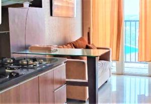 una cucina con tavolo e divano in una camera di Apartemen Paragon Village by CV Kita Property & Partner a Tangerang