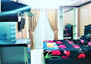 a bedroom with a bed and a television in it at Apartemen Paragon Village by CV Kita Property & Partner in Tangerang