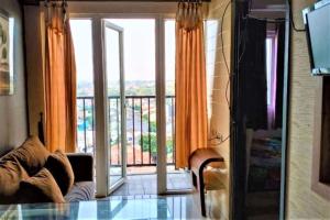 ein Wohnzimmer mit einem großen Fenster mit Aussicht in der Unterkunft Apartemen Paragon Village by CV Kita Property & Partner in Tangerang