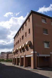 un gran edificio de ladrillo en una calle de la ciudad en Olly Apartments en Bolonia