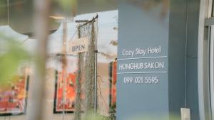 色军Honghub Sakon Hotel的建筑物上的街道标志,有商店标志