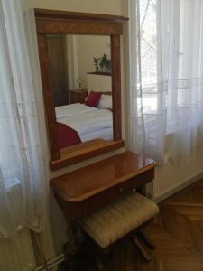 a mirror in a room with a bed and a bench at TulipánVendégház in Keszthely