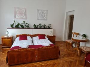 Un dormitorio con una gran cama de madera con almohadas rojas en TulipánVendégház en Keszthely