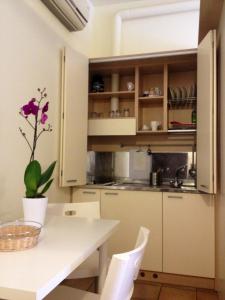 a kitchen with white cabinets and a table at Olly Apartments in Bologna
