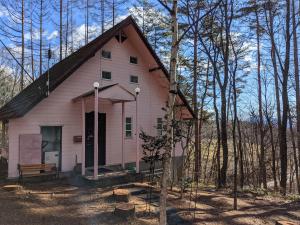 a pink house in the middle of the woods at Asuka's House 八ヶ岳 in Hokuto