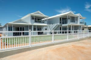 a white fence in front of a white house at Wallaroo Beachfront Tourist Park in Wallaroo