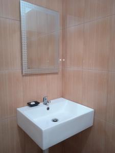 a bathroom with a white sink and a mirror at Madu Tiga Beach and Resort in Tanjung Pinang 