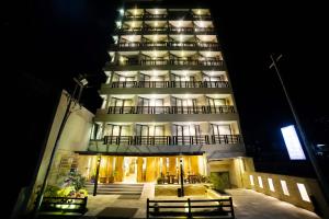 a tall building with benches in front of it at night at Aabas Pokhara by Barahi Hospitality in Pokhara