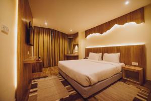a bedroom with a large bed and wooden walls at Aabas Pokhara by Barahi Hospitality in Pokhara