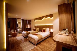 a large hotel room with two beds and a living room at Aabas Pokhara by Barahi Hospitality in Pokhara