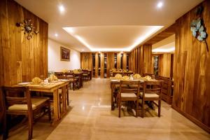 a restaurant with wooden walls and wooden tables and chairs at Aabas Pokhara by Barahi Hospitality in Pokhara